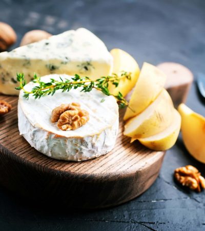 cheese with nuts and honey on wooden board